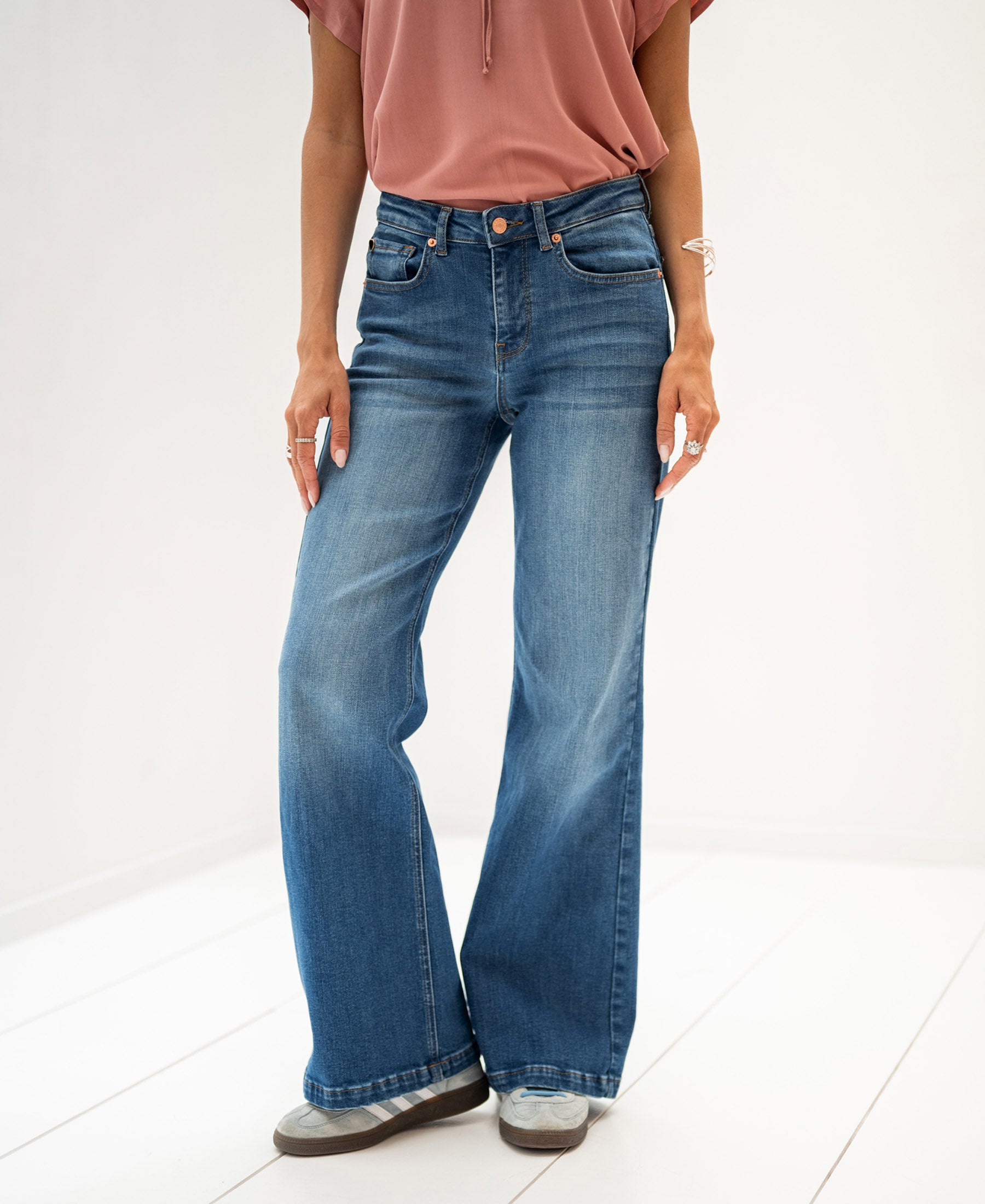 Wide-leg stonewash jeans in blue from Plein Publique shown worn by a person, standing on a white floor.