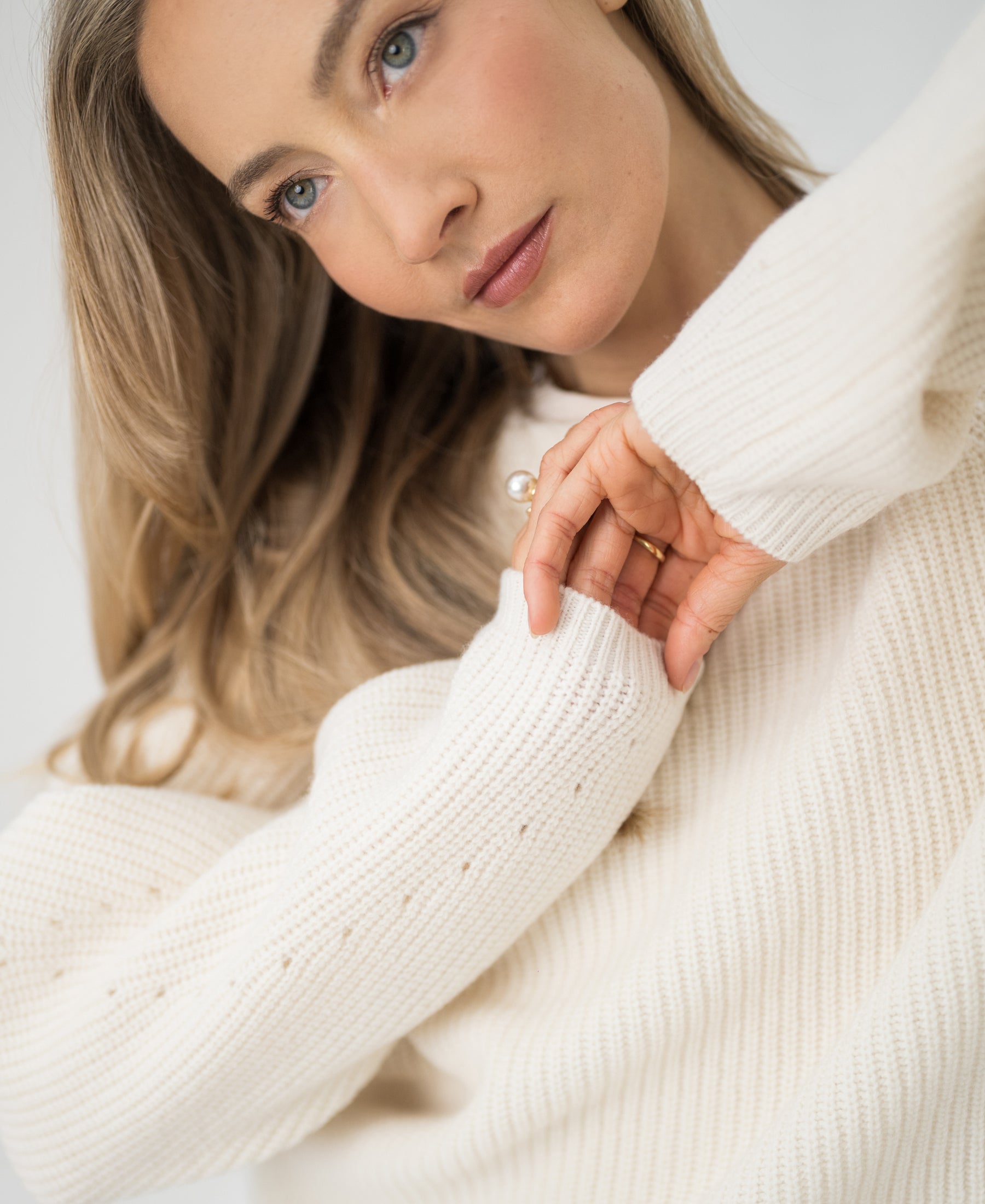 Cream merino wool sweater in cardigan stitch, shown from the front.