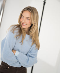 Light blue merino wool sweater shown against a bright background.