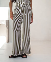 Ivory-cocoa striped summer trousers displayed indoors against a light background.