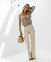 Woman wearing a sand-colored merino wool vest in sunlight.