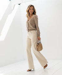 Cream-colored PLEIN PUBLIQUE Jeans LES DEUX shown in a bright, white room.