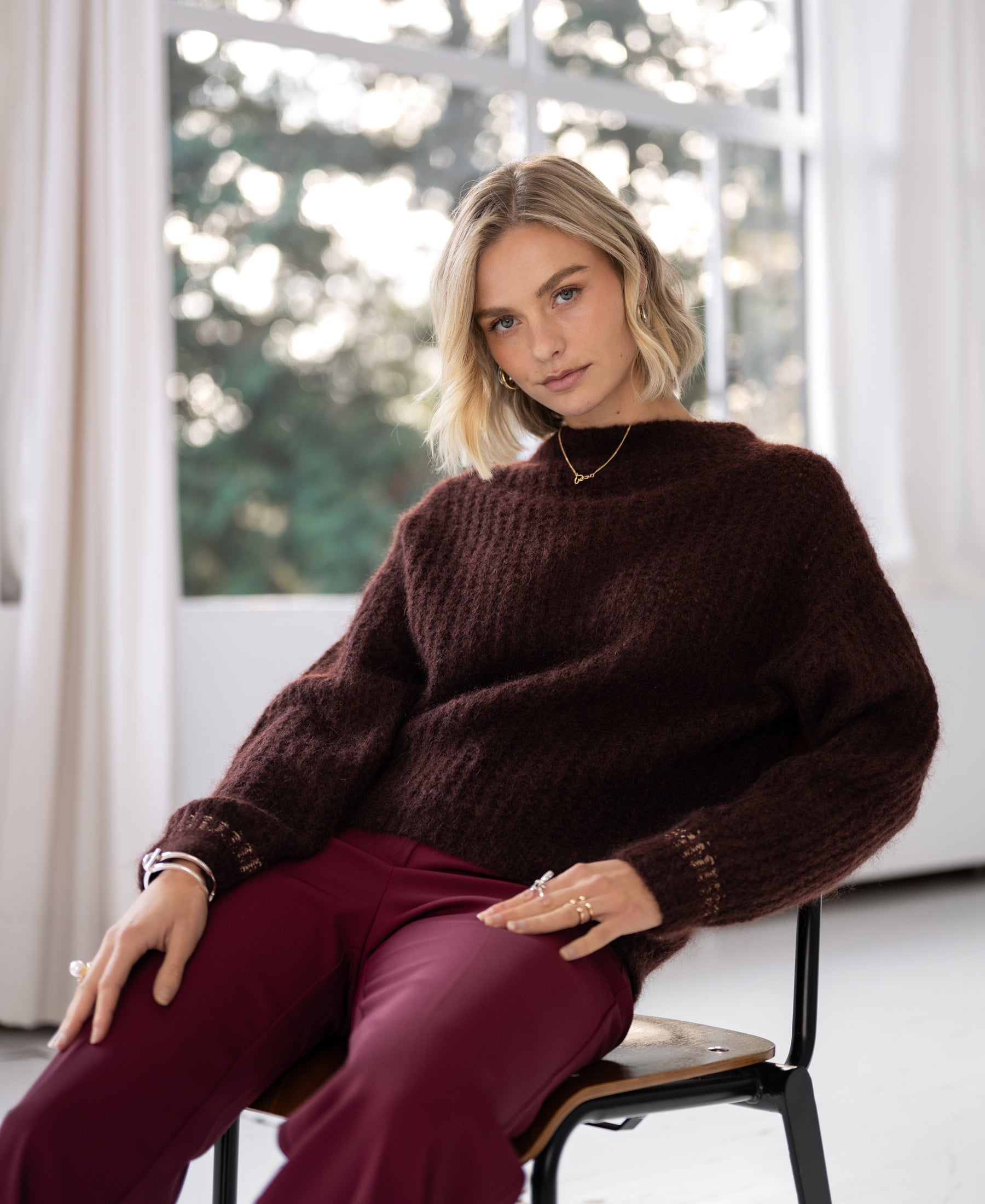 Red mohair sweater LA DOUCE by PLEIN PUBLIQUE, shown worn, with white curtains in the background.