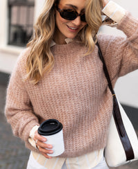 Woman wearing a PLEIN PUBLIQUE mohair sweater in fudge brown, shown outdoors.