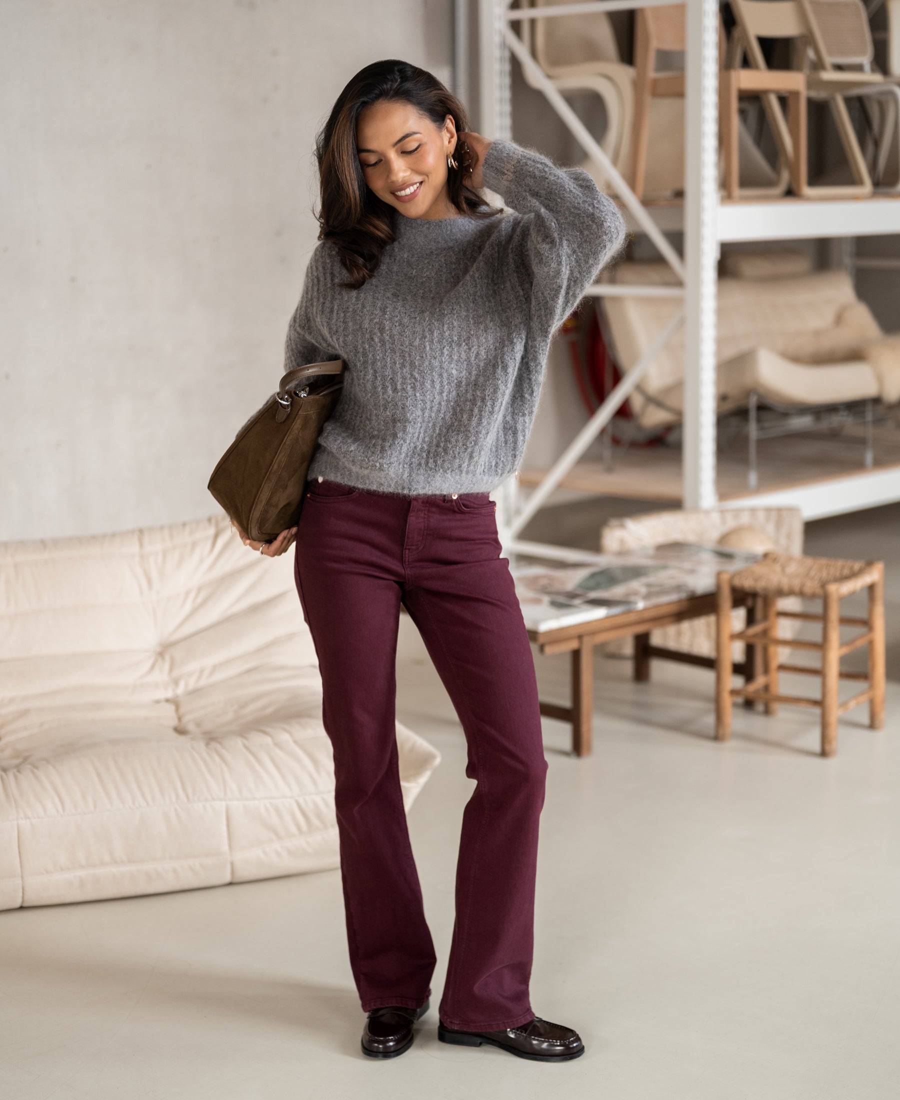 Light grey mélange mohair sweater by PLEIN PUBLIQUE, shown on a woman in a modern, cozy room.