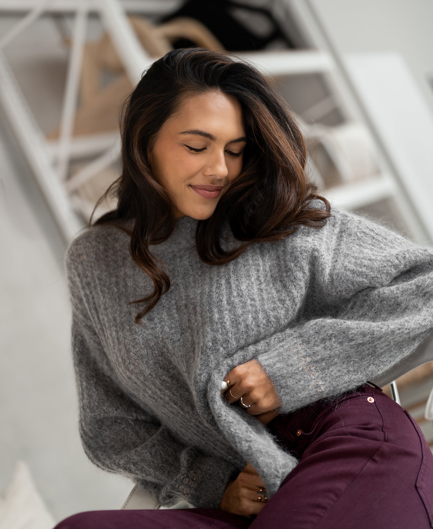 Woman wearing a grey melange mohair sweater indoors.