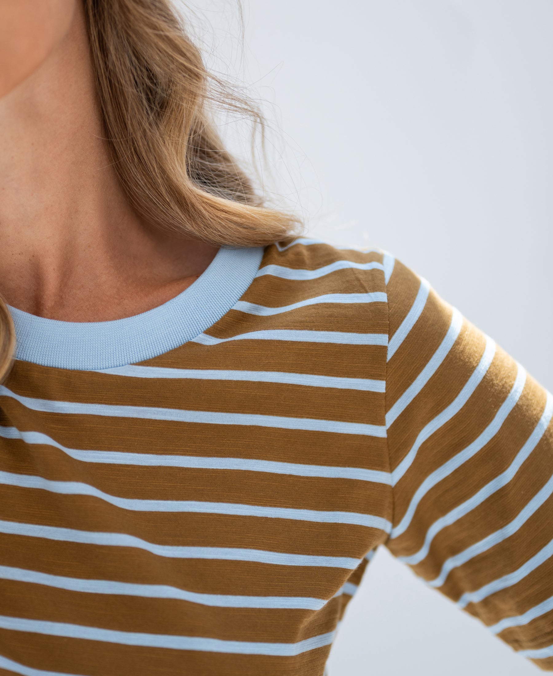 Close-up of PLEIN PUBLIQUE striped T-shirt in gold yellow and light blue.
