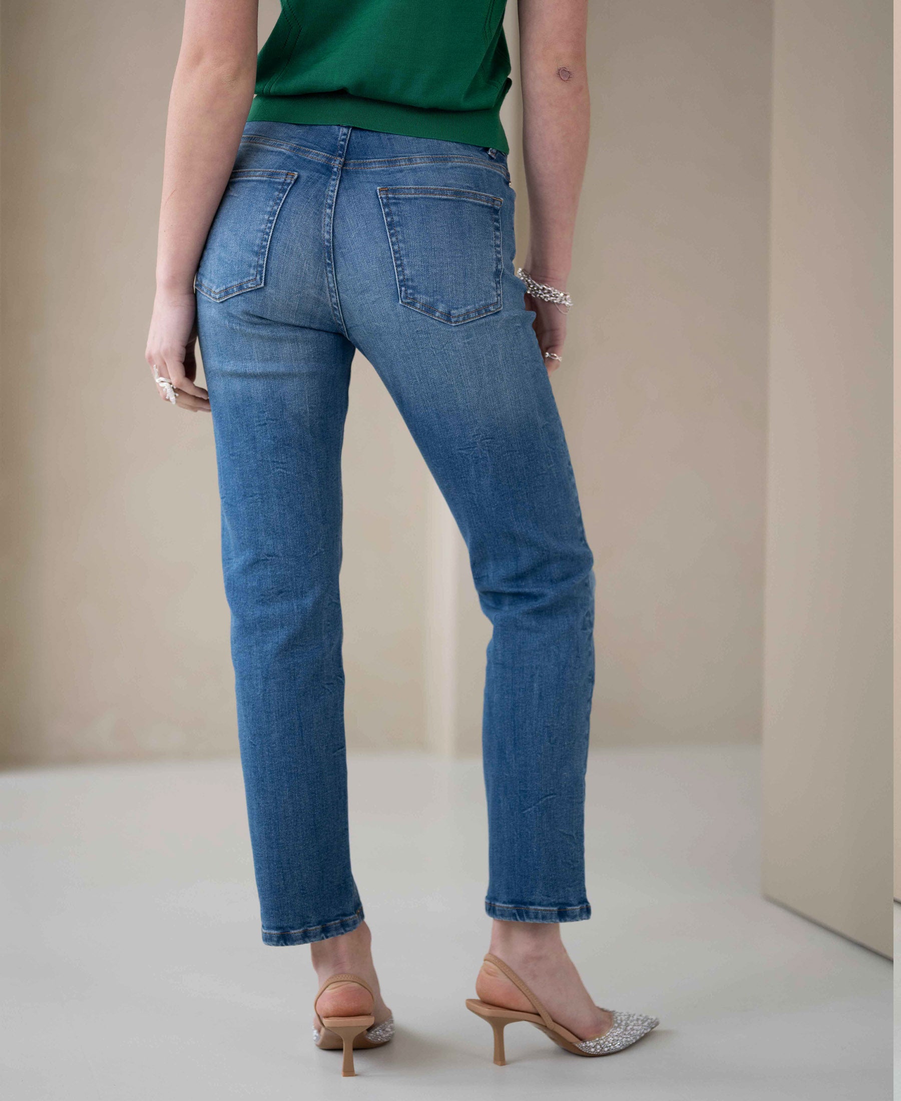 Back view of person wearing stonewashed cropped jeans.