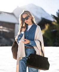 Woman wearing a light blue Tencel denim blouse in a stonewashed finish.