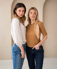 Woman wearing stretch denim cropped jeans in a stonewash finish, standing in a neutral setting.
