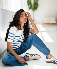 Woman wearing the PLEIN PUBLIQUE ESISA Breton sweater in ivory and denim blue.