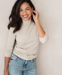 PLEIN PUBLIQUE LE FABIAN beige turtleneck sweater displayed against a light-colored wall.