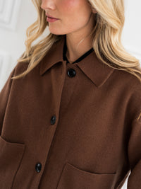 Camel wool jacket with large pockets, ideal for transitional weather. Product shown from the front. Model's face partly visible.
