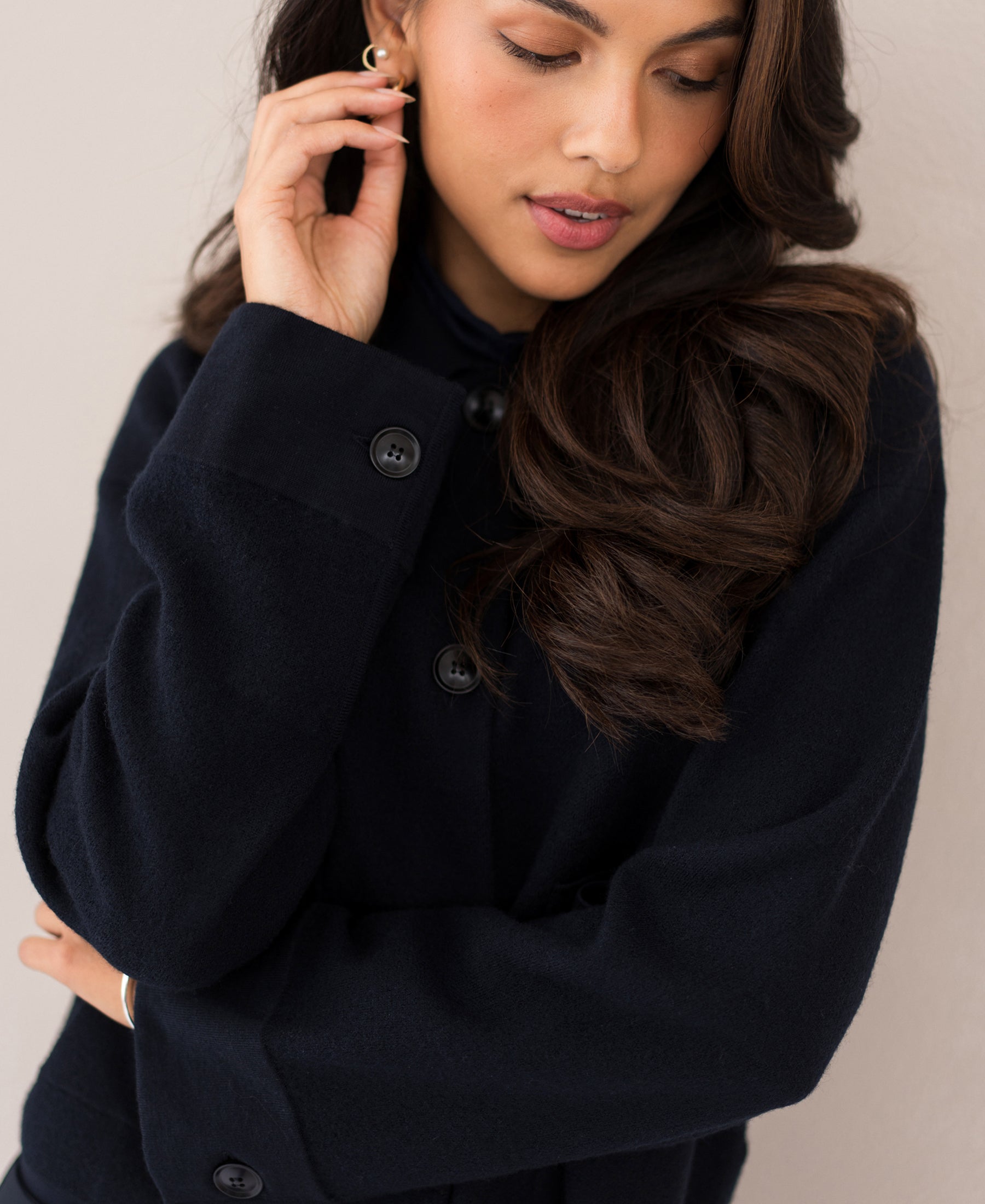 Dark blue wool jacket by PLEIN PUBLIQUE, LA FAYE style, shown on a woman looking down.