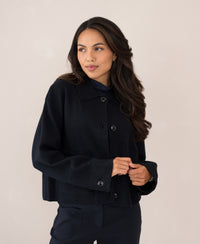 Navy wool blazer LA FAYE by PLEIN PUBLIQUE shown against a beige background.