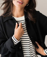 Woman wearing black wool LA FAYE jacket, holding the lapel.