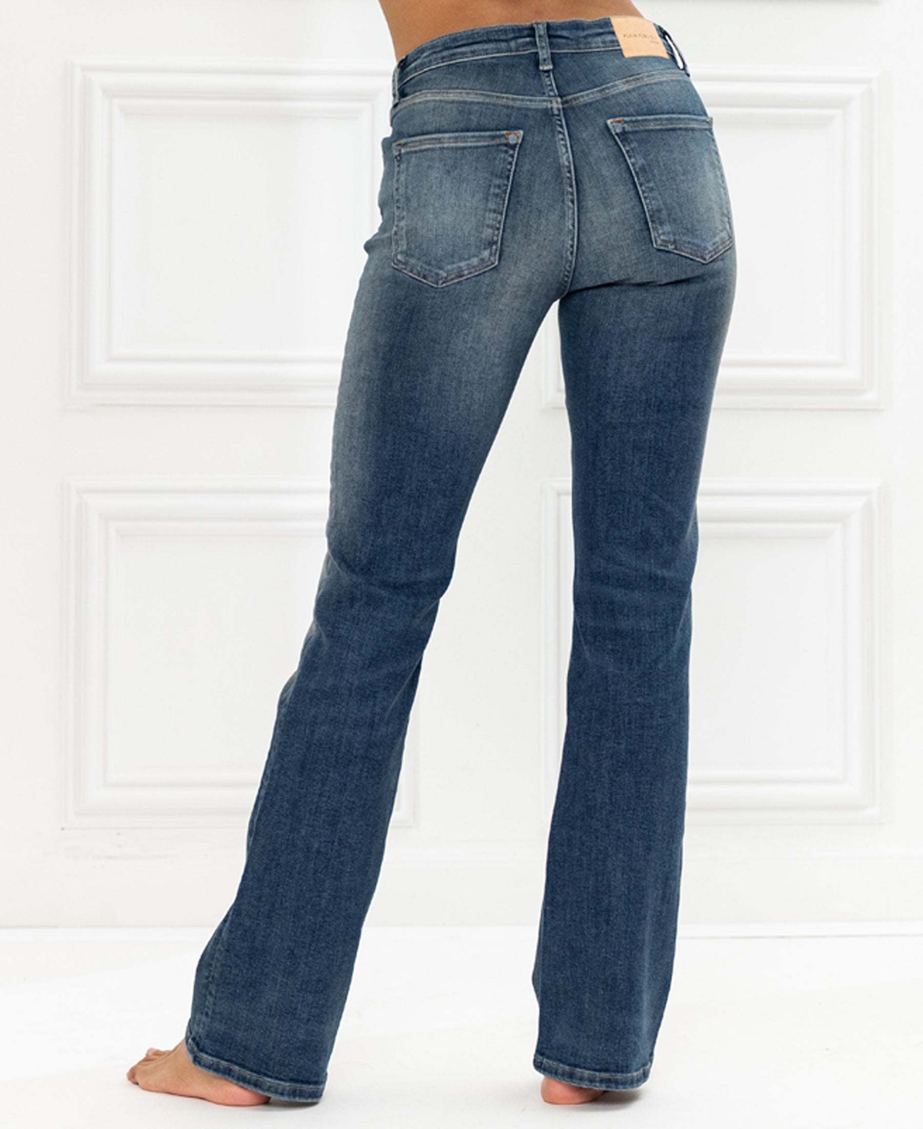 High-waisted blue vintage flared jeans in denim, shown from the back.