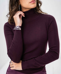 Woman wearing an aubergine Merino wool turtleneck sweater by PLEIN PUBLIQUE.