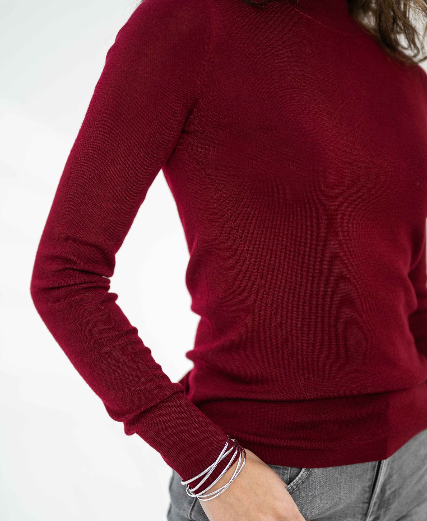 Woman wearing a dark red merino wool turtleneck sweater.