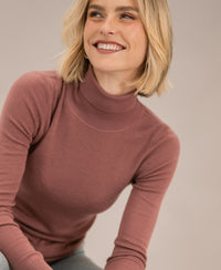 Dusty pink merino wool turtleneck sweater, front view.