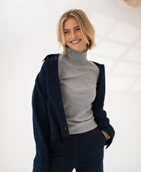 Merino wool turtleneck sweater in feather grey by PLEIN PUBLIQUE, shown in a brightly lit room.