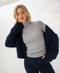 Merino turtleneck sweater LA FORTE in Feathergrey by PLEIN PUBLIQUE, shown with hand near face and eyes closed.