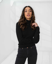 Black merino wool turtleneck sweater by PLEIN PUBLIQUE shown in a bright, minimal white room.