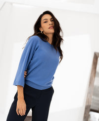 Lavender-blue merino wool sweater with 3/4 kimono sleeves, shown on a woman against a white background.