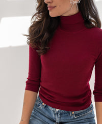Woman wearing PLEIN PUBLIQUE turtleneck sweater LE FABIAN in dark red, indoors.