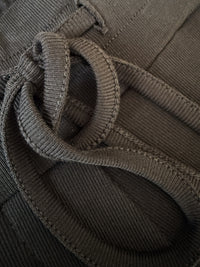Close-up of charcoal lounge pants with drawstring bow and silky viscose jersey fabric.