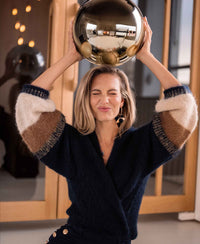 Navy blue striped fluffy vest in wool blend, shown on woman with eyes closed.