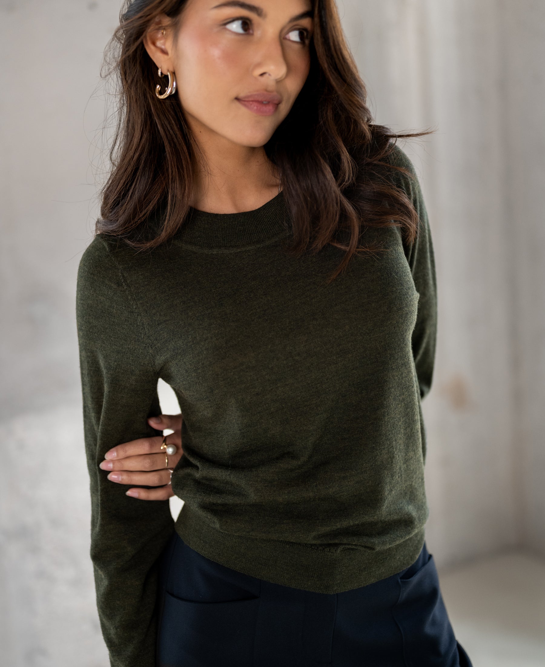Bottle green Merino wool LA GIGI sweater by PLEIN PUBLIQUE, shown from the side.