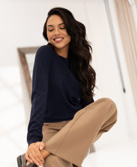 Navy blue PLEIN PUBLIQUE LA GIGI Merino wool sweater shown on a person seated in a well-lit space.