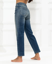 Back view of blue vintage cropped jeans in a classic fit, shown against a white wall.