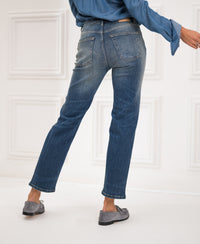 Blue vintage cropped jeans, shown from the back on a person standing indoors with one leg bent.