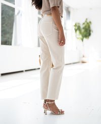 Beige shirt by PLEIN PUBLIQUE, shown indoors in sunlight, worn by a woman facing away.