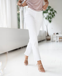 White straight-leg cropped jeans shown in a bright room with white floors.