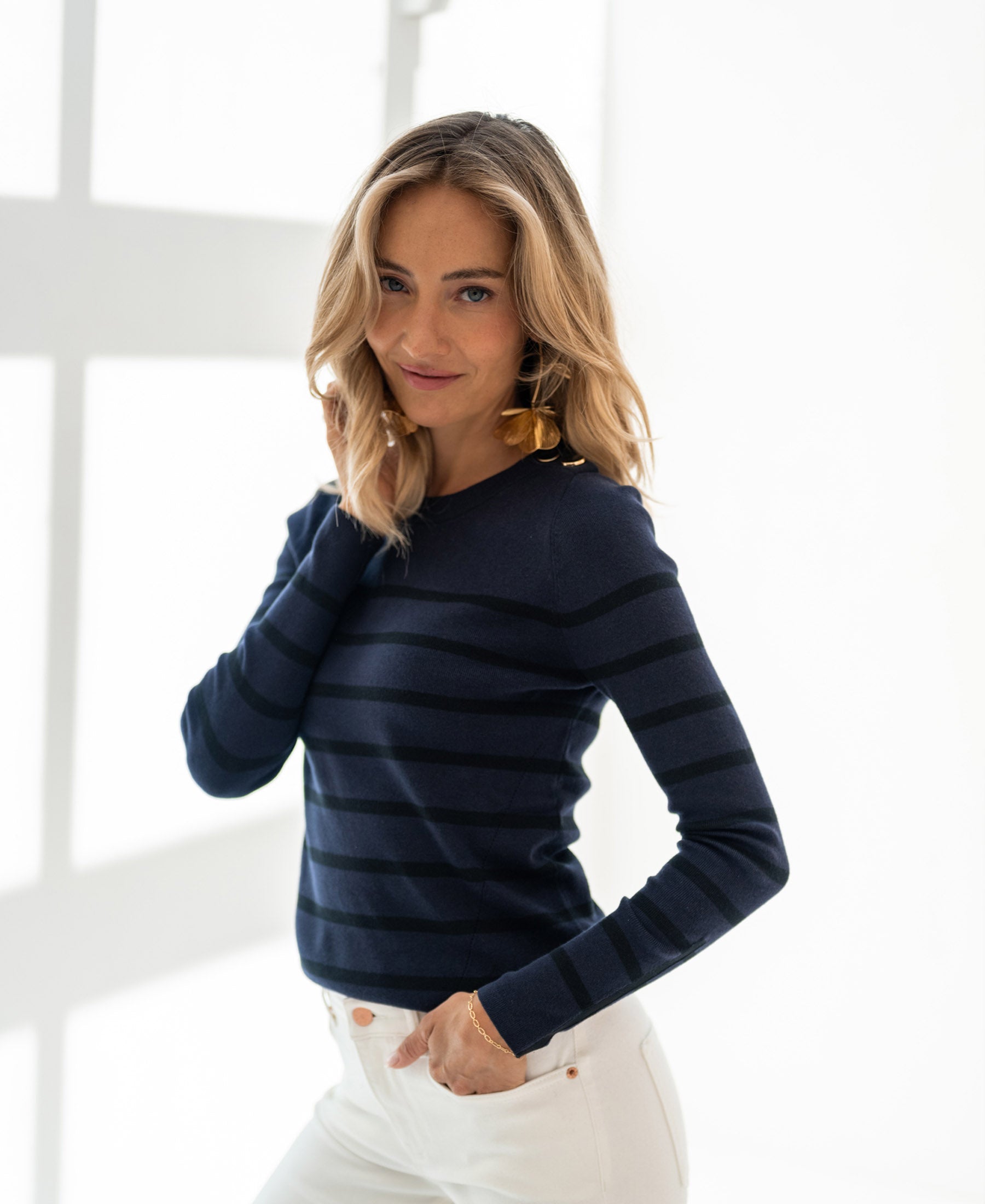 Woman wearing navy-black PLEIN PUBLIQUE L'ELISA sweater, posing indoors.