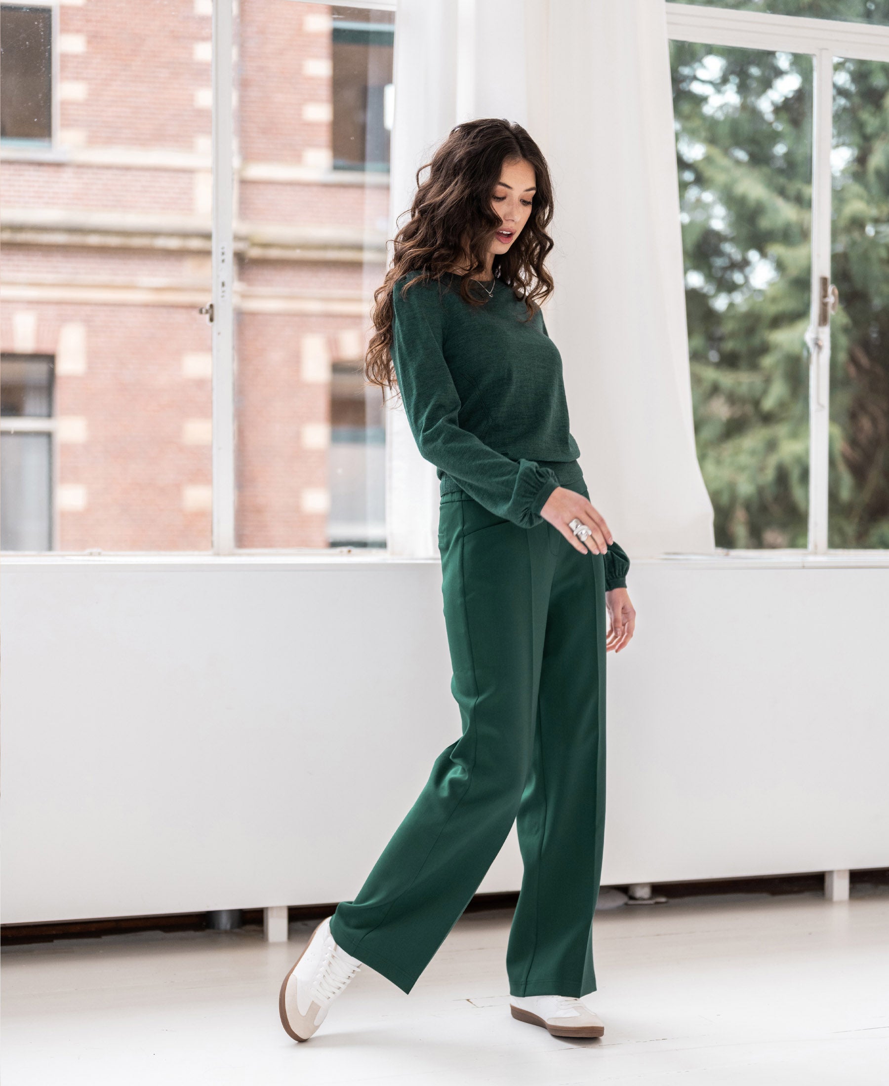 Greenish merino wool sweater with balloon sleeves shown indoors near large windows.