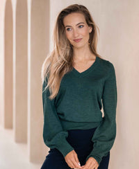 Greenish PLEIN PUBLIQUE Merino wool V-neck sweater LA VICTORIA shown on model indoors.