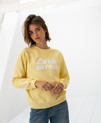 Front view of the LA HARPER Yellow sweater by PLEIN PUBLIQUE, shown in a bright, minimal white room.