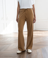 Light camel lounge pants shown in a bright room.