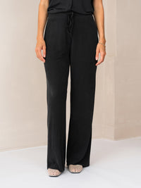 Charcoal lounge pants by PLEIN PUBLIQUE, shown indoors.