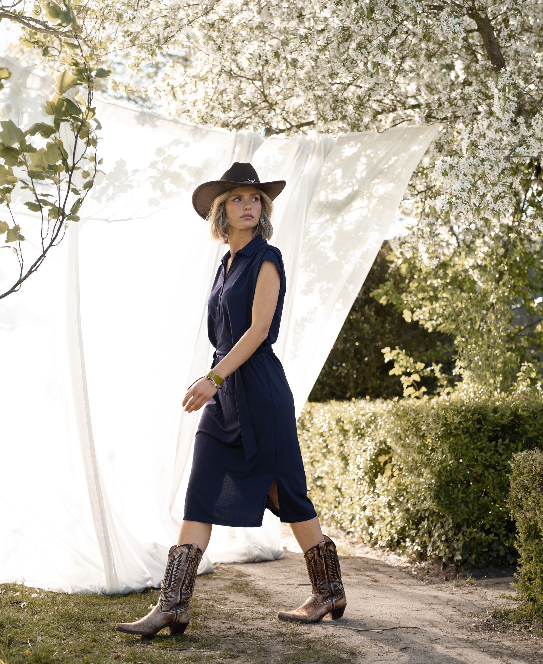 Navy blue PLEIN PUBLIQUE Travel polo dress INES shown on model, standing in front of a white backdrop.