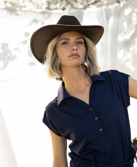 Navy travel polo dress with collar, shown outdoors on a woman, front view.