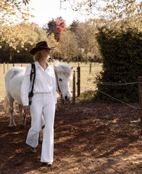 Wide leg white jeans by PLEIN PUBLIQUE shown outdoors on a sunny day.