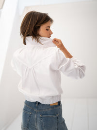 White denim jacket shown from the side, collar held by model.