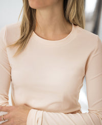 Luxe long sleeve T-shirt in blush by PLEIN PUBLIQUE, sustainable women's clothing; model's face partially out of frame.
