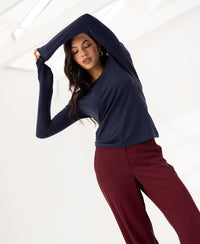 Navy long sleeve Luxe T-shirt by PLEIN PUBLIQUE, shown indoors with one arm raised above head.