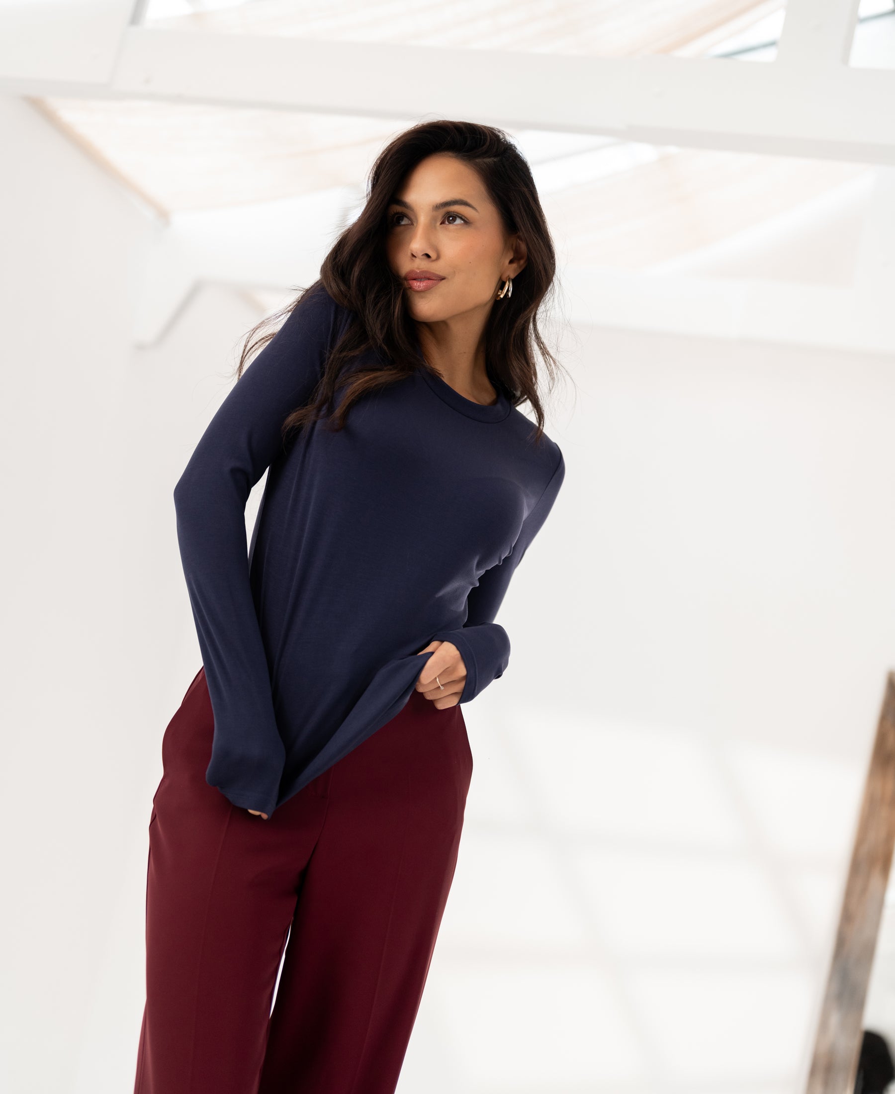 Woman wearing a Luxe long sleeve T-shirt LA JANE in navy by PLEIN PUBLIQUE, shown indoors.